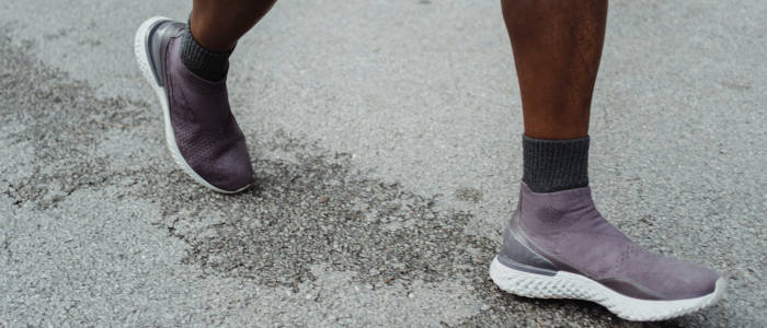 tênis nos pés de um homem negro caminhando