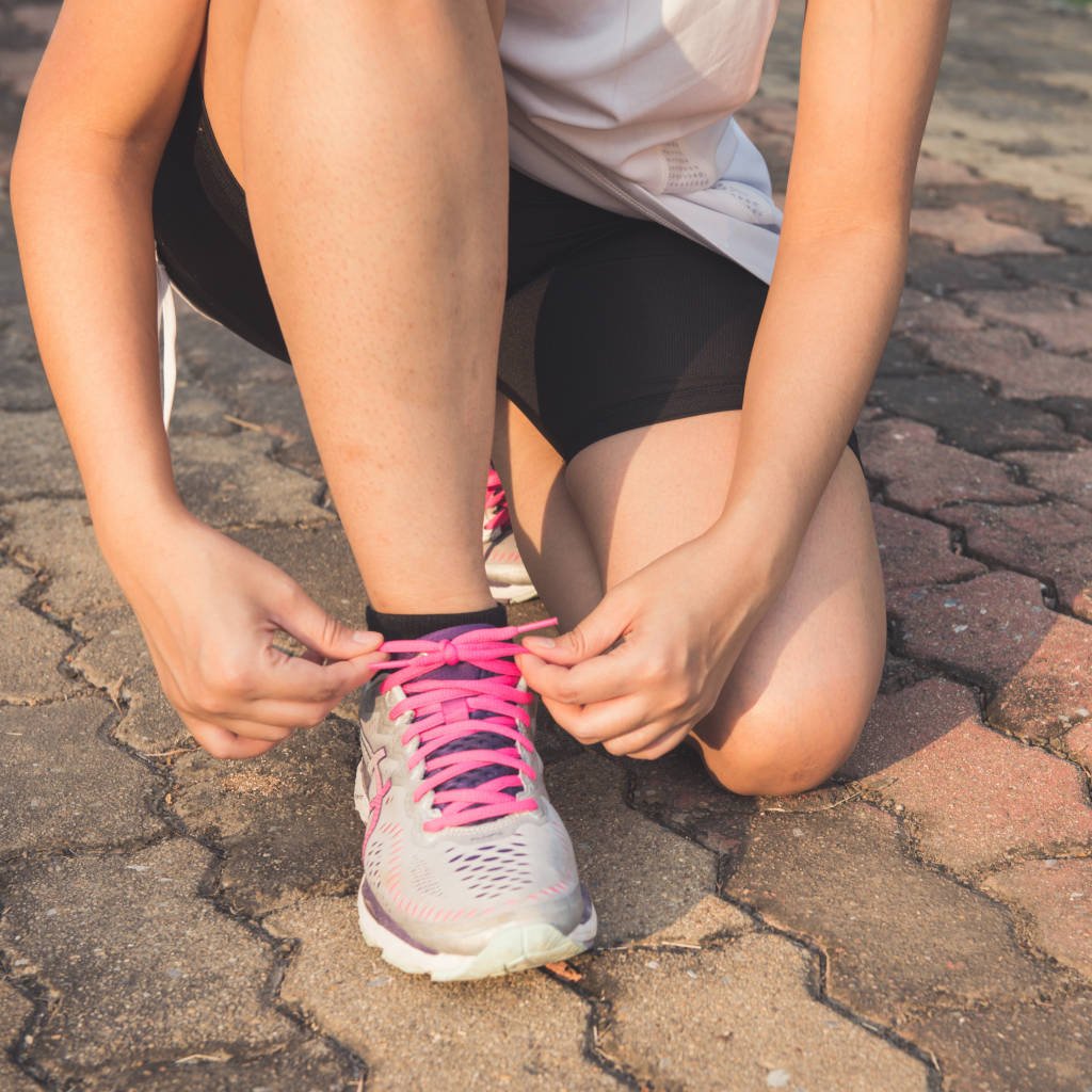 Mulher amarrando o tênis para corrida pexels-tirachard-kumtanom